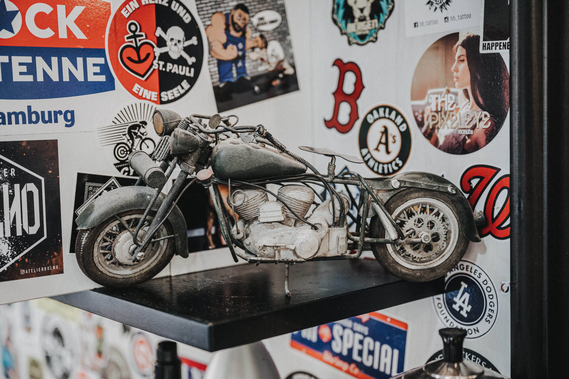 Foto eines Modell-Motorrades auf einem schwarzen Regal beim Innenstadt Friseur